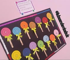 there are many lollipops on the black board with yellow ribbons around them