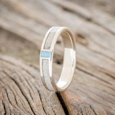 a white gold wedding ring with blue stone inlays on the outside of it