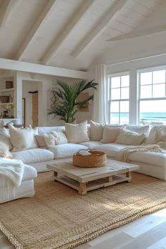 a living room filled with white furniture and lots of pillows on top of a rug