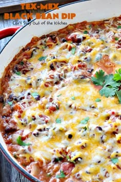 a casserole dish with black beans, cheese and cilantro