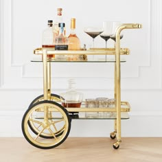 a gold bar cart with drinks on it