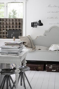 a living room filled with furniture and lots of books on top of a white table