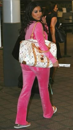 a woman in pink is carrying a handbag