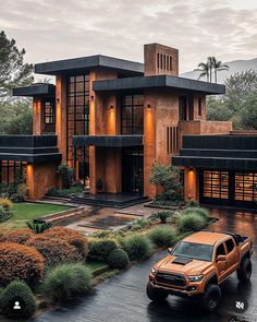 an orange truck parked in front of a large house