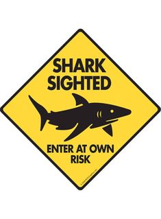 a yellow sign with a shark on it says, shark signed enter at own risk