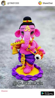 a small crocheted ganeshi sitting on top of a yellow and purple base