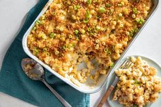 a casserole dish with macaroni and cheese on a blue napkin next to a fork