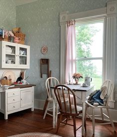 a dining room table and chairs in front of a window