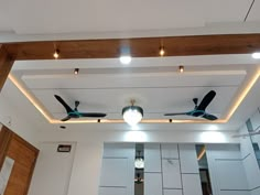 the ceiling fan is hanging from the wooden beam in the room with white walls and doors