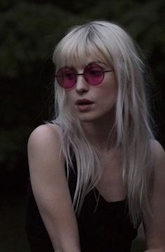 a woman with long blonde hair and pink sunglasses