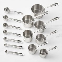 stainless steel measuring cups and spoons on a marble surface