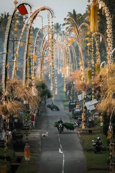 an outdoor area with lots of decorations on the trees and motorcycles parked along the road