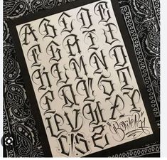 some type of writing that is on top of a black and white cloth with paisley designs