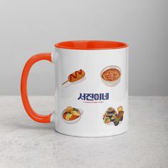 an orange and white coffee mug with different food items on the inside, in front of a gray background