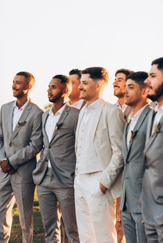 a group of men standing next to each other wearing suits and bow ties on their heads