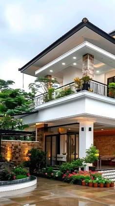 a large white house with plants on the balcony