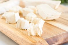 several pieces of cheese on a wooden cutting board