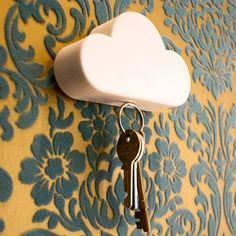 there is a cloud shaped key holder attached to the wall with two keys in it