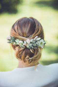 a woman with flowers in her hair wearing a white dress and a flower headpiece