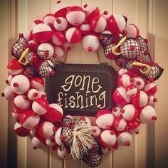 a red and white wreath that says gone fishing on it with balloons attached to the front door