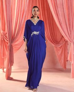 Wrap yourself in luxury with this full-length draped kaftan, adorned with exquisite embellishments along the neckline, sleeves, and waist. This statement piece exudes elegance and sophistication, perfect for making a glamorous entrance at any event. Blue Kaftan Dress, Kaftan Embroidery, Kaftan Style Dresses, Blue Kaftan, Blue Drapes, Personal Shopping Service, Pakistani Wedding Outfits