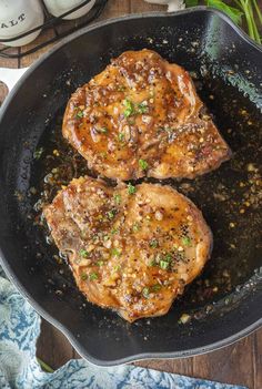 two pork chops cooking in a skillet