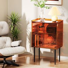 a white chair sitting next to a wooden cabinet with an electronic device on top of it