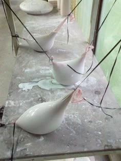 three white vases sitting on top of a counter next to each other in front of a mirror