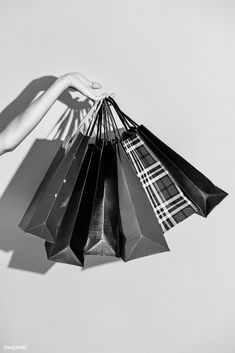 black and white photograph of hand holding shopping bags