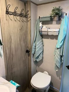 a bathroom with towels hanging on the wall and a toilet in the corner next to it