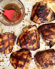 grilled pork chops on parchment paper next to a jar of bbq sauce