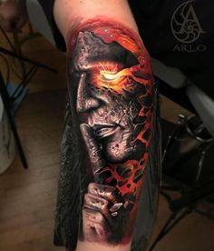 a man's arm with a tattoo on it that has an image of a demon holding