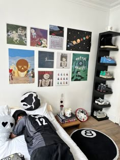 a person laying on top of a bed in a room with pictures hanging on the wall