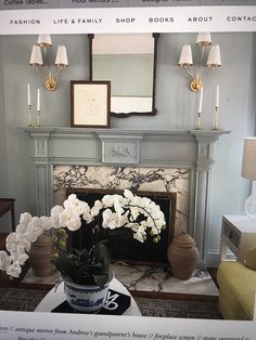 a living room with a fire place and flowers on the coffee table in front of it