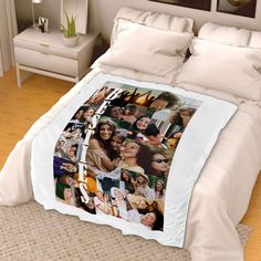 a bed covered in white sheets with pictures on it's covers and pillow cases