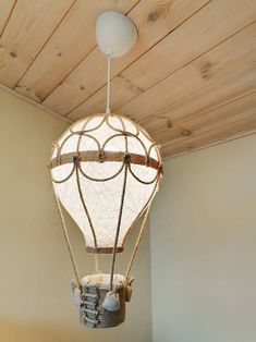 a hot air balloon hanging from the ceiling in a room with wood planks on the ceiling