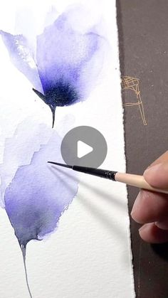 someone is painting flowers with watercolors on paper