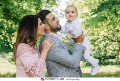 a man and woman holding a baby in front of some trees with the caption happy father's day