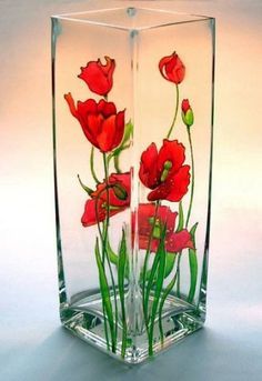 a glass vase with red flowers in it