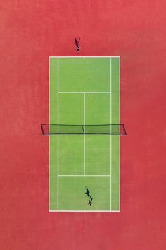 two people are playing tennis on a red and green court with one person jumping up to hit the ball