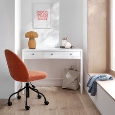 an orange chair sits in front of a white desk with drawers and a lamp on it