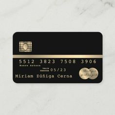 a black and gold credit card on a marble surface