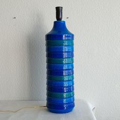 a blue vase sitting on top of a white table