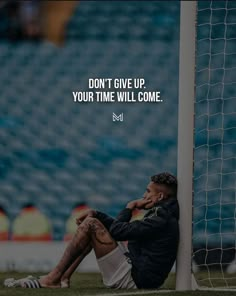 a man sitting on the ground next to a soccer ball