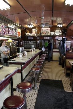 the inside of a diner with stools and tables