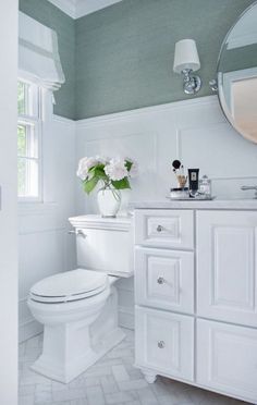 a white toilet sitting next to a sink in a bathroom