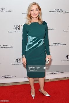 a woman in a green dress poses on the red carpet at an american ballet foundation event