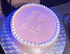 a pink cake with white frosting that says happy birthday on it sitting on a table