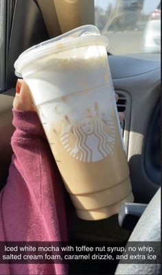 a cup of coffee sitting on top of a car seat next to a person's head