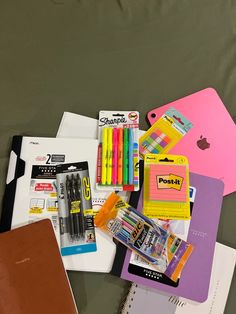 various school supplies are laid out on a bed